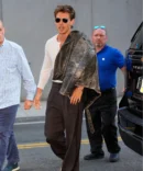 Austin butler with a fin grain distressed brown jacket on his shoulder